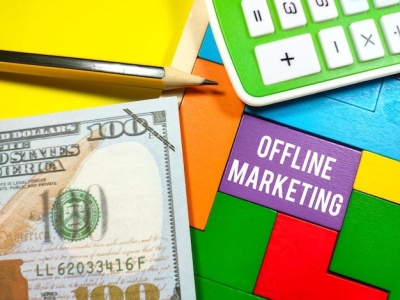 business-concepttext-offline-marketing-writing-wooden-puzzle-with-calculatorpencil-fake-money-yellow-background_406607-3259