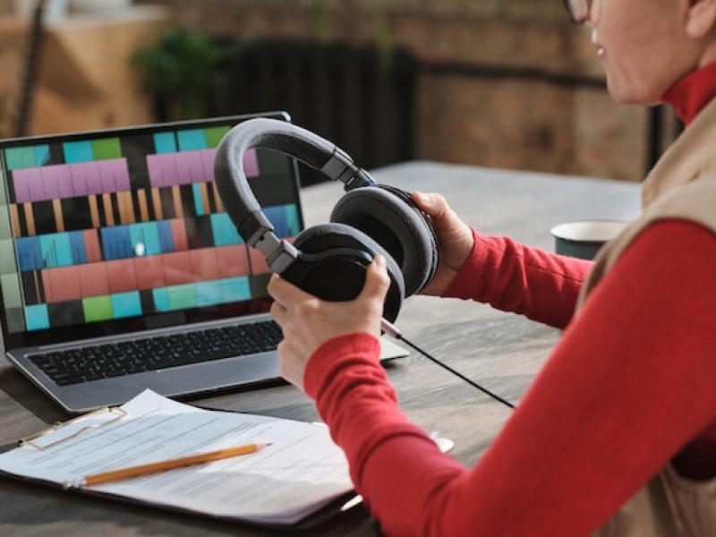 close-up-woman-headphones-sitting-table-with-laptop-recording-podcast-online-show-radio-studio_249974-8362