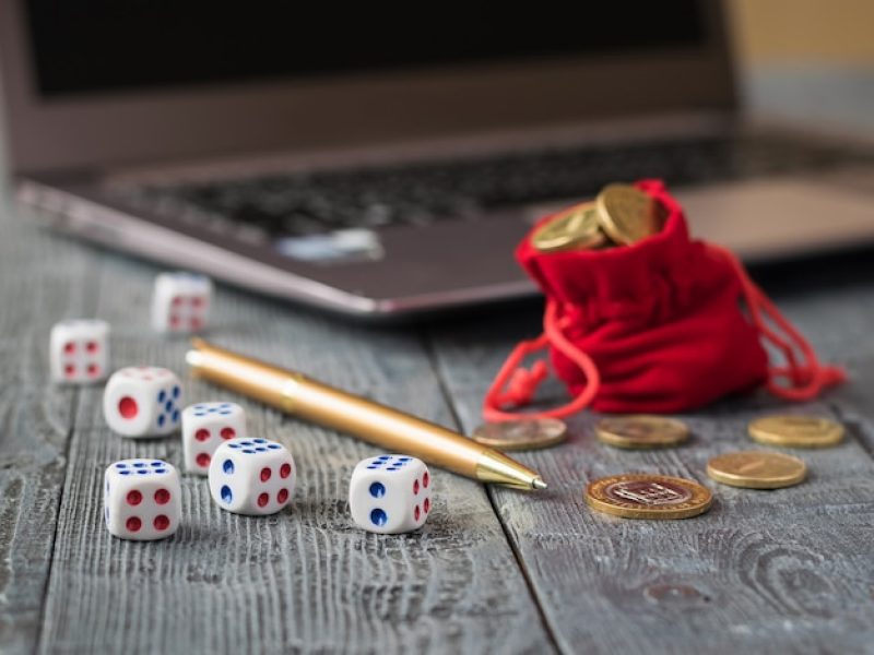 dice-wooden-table-with-notebook-pen-money-workplace_94064-1022