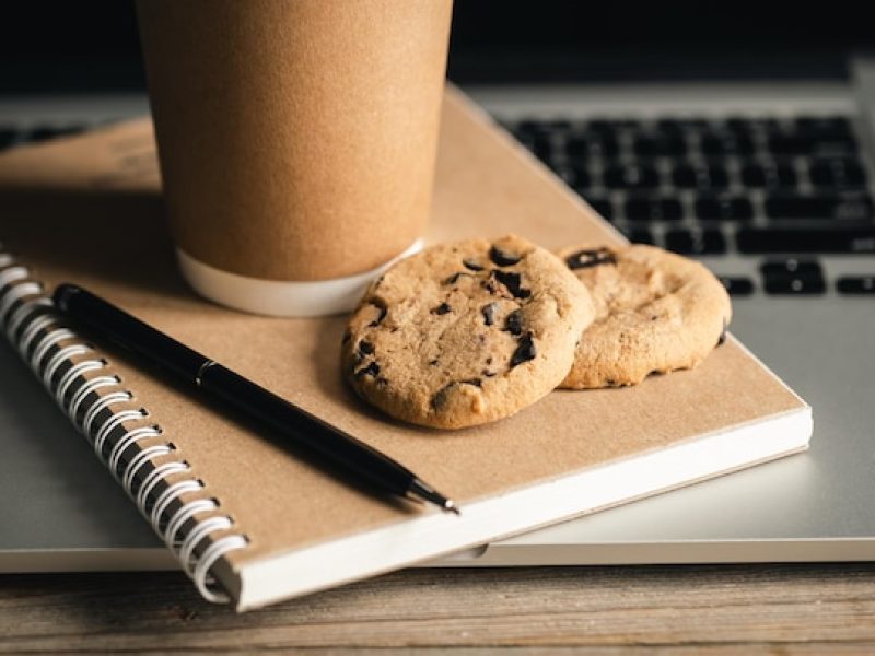 trendy-office-concept-craft-paper-cup-cookies-recycled-notebook-laptop-keyboard_919229-619
