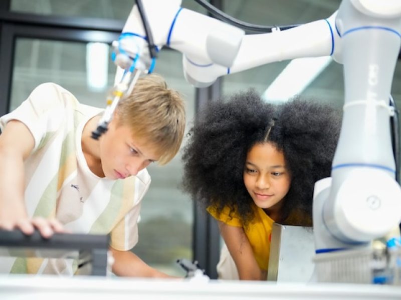 two-children-looking-robot-with-robot-arm_35752-14904