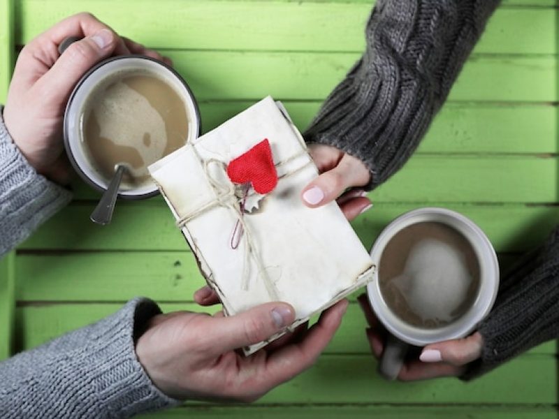 young-couple-drinking-hot-coffee-wooden-table-date_494741-24590