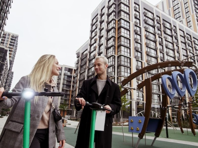 young-couple-spending-good-time-electric-scooters-modern-apartment-blocks-background-man-woman-rented-e-scooters-fast-trip-concept-eco-friendly-transport-autmn-big-city-concept_341052-3721